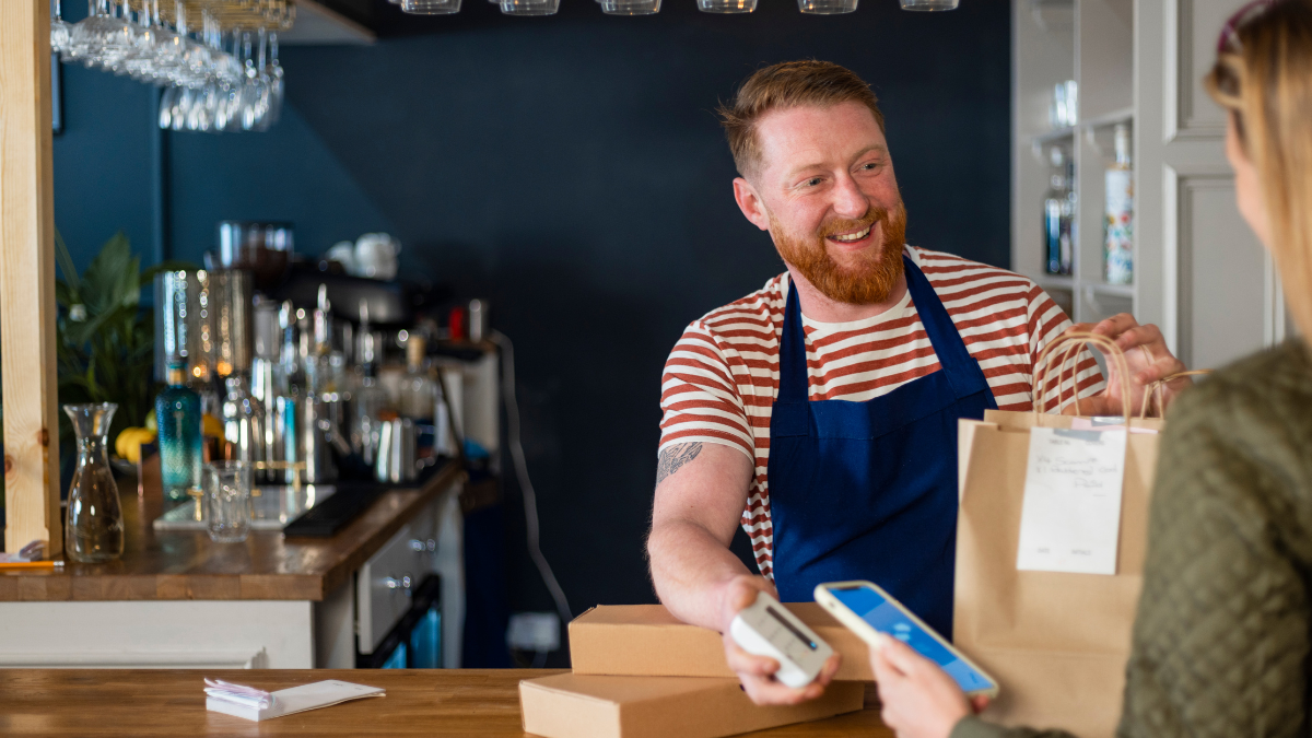 Restaurant operator hands a to-go back to a customer